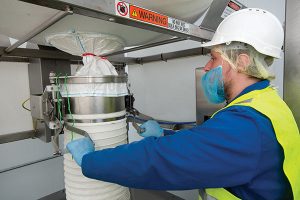 Once the bag spout is secured by a SPOUT-LOCK™ clamp ring, the operator releases the drawstring (red). Constant downward tension is maintained by a TELE-TUBE™ telescoping tube as the bag empties and elongates.